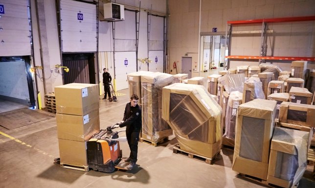 Furniture is being unloaded from the truck and in to the storage 